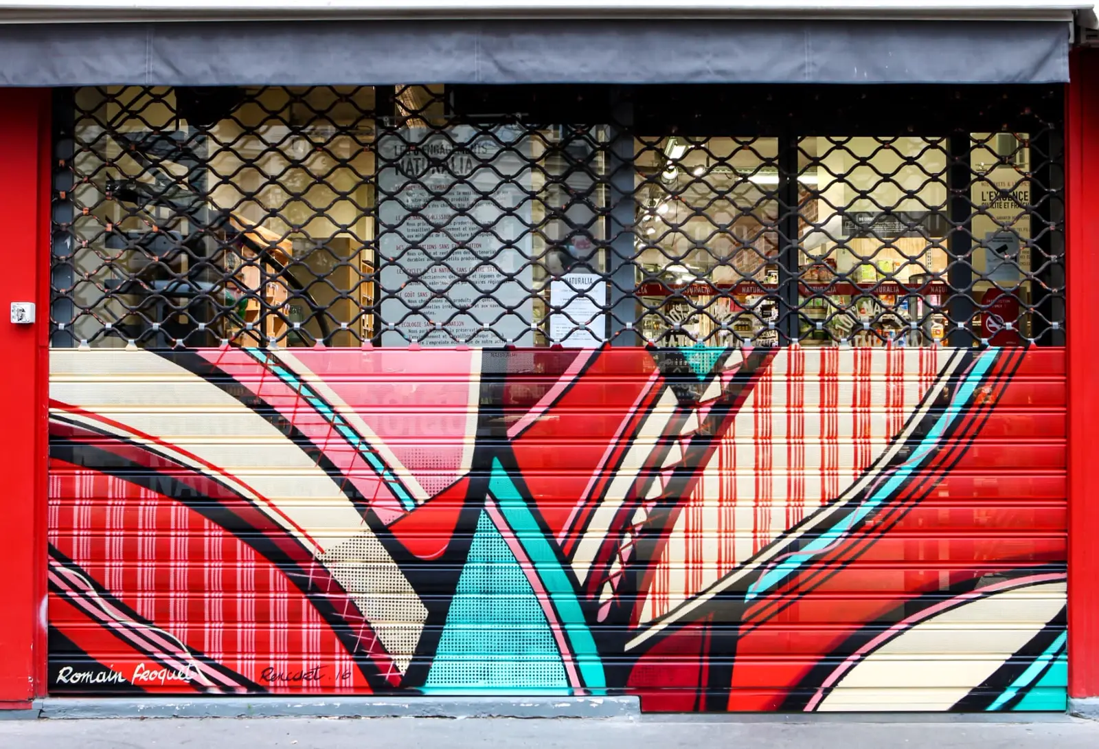 Rideau de fer Naturalia peint en rouge et turquoise par le street artiste Romain Froquet — rue de Crussol, Paris