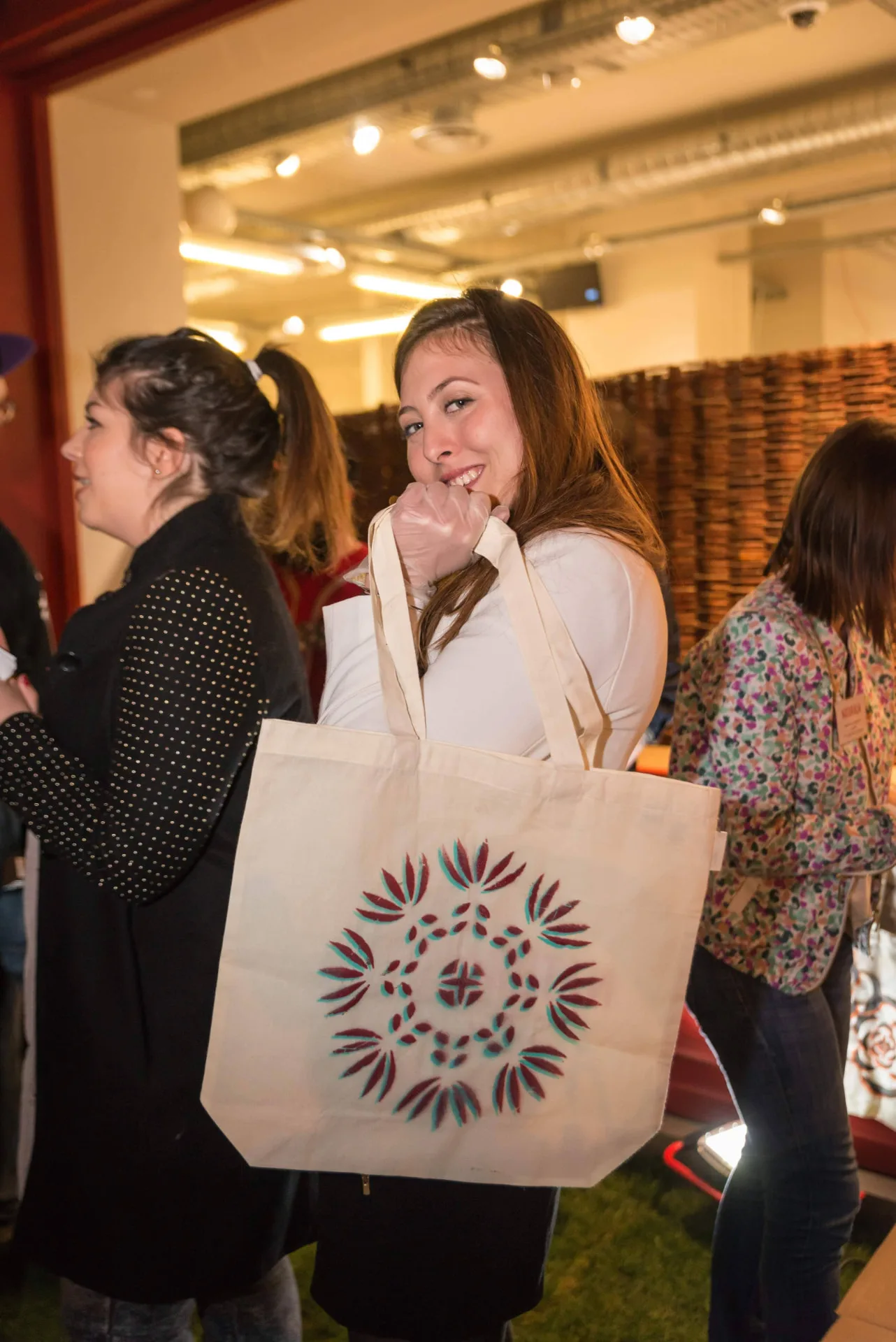 Invitée présentant son totebag personnalisé au pochoir lors de la soirée de lancement Naturaliart