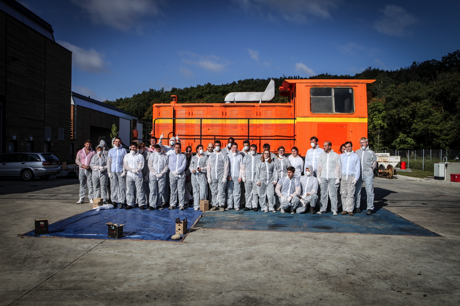 La promo Colas Rail, en combinaisons, devant la locomotive avant l'atelier